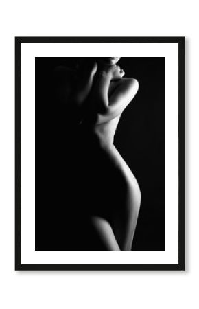 Nude Woman silhouette under light in the dark