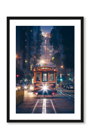 Classic view of historic traditional Cable Cars riding on famous California Street at night with city lights, San Francisco, California, USA