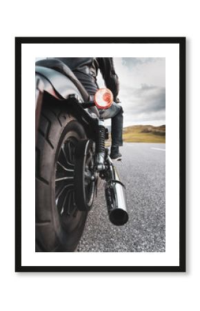 Driver riding motorcycle on an asphalt road in mountain