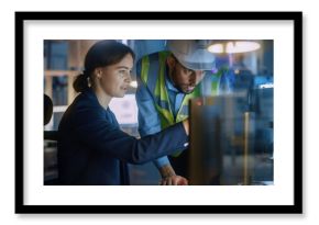 Modern Factory Office: Male Project Manager Talks to a Female Industrial Engineer who Works on Computer. Professional Teamwork, Specialists Solving Problems, Finding Solutions