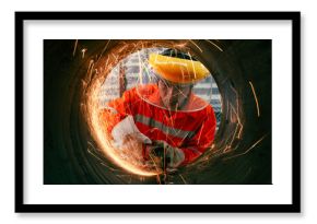 Highly skilled workers wearing industrial uniforms and Welded Iron Mask at Steel use electric wheel grinding on steel structure in the construction industrial factory.industrial safety first concept
