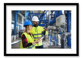 Engineering manager and mechanic worker doing routine check up in industrial factory