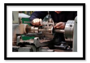 Skilled worker precision measuring metal component in industrial workshop during daytime