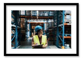 Female warehouse worker inspecting inventory with clipboard