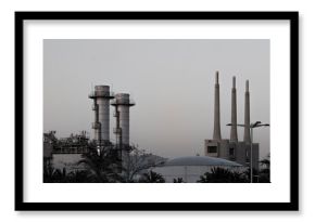 Distant view of an industrial complex with multiple smokestacks, highlighting urban manufacturing and energy sectors.