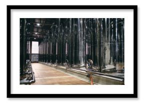Rows of shiny stainless steel reservoirs placed in bright industrial area of modern factory
