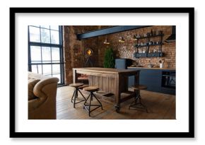 Side view on a wooden table and spacious industrial loft kitchen with vintage decor and black cabinets