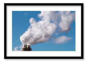 Plumes of steam rising from industrial chimneys into a blue sky