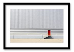 the sheet metal factory wall with the red door entrance