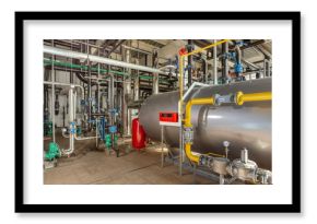 Interior of an industrial boiler room with boilers, many pipes, valves and sensors