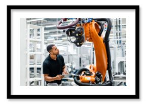 Technician examining industrial robot in a factory