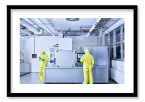 Chemists working in industrial laboratory, wearing protective clothing in the clean room