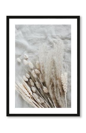Dry grass bouquet top view on beige linen fabric texture.Flowers background . Copy space.