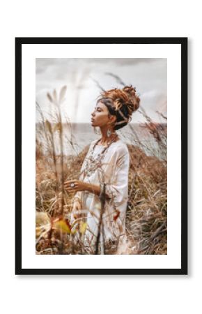 Beautiful young woman in ethnic dress on a field close up portrait