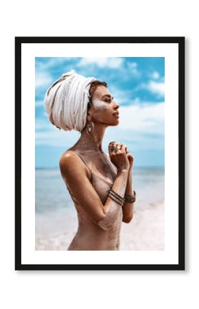 beautiful young tribal woman in turban at blue sea and sky background