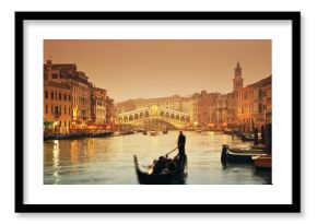 Rialto Bridge and gondolas at a foggy autumn evening in Venice.