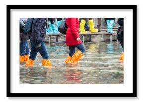 Close Up of legs with boots due to the high water in Venice.