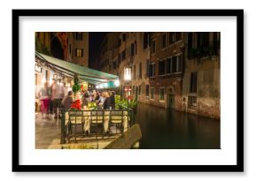 Night view of canal and restaurant in Venice, Italy