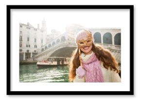 Smiling woman hiding behind Venice Mask near Rialto Bridge