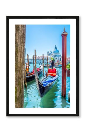Venice touristic attraction Italy. / View at gondola dock station and church Santa Maria di Salute in background, unique touristic city Venice, Italy.