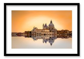 Isolated Basilica di Santa Maria della Salute at orange colors reflected on the water surface, Venice, Italy.