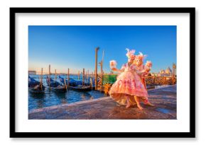 Famous carnival masks against gondolas in Venice, Italy