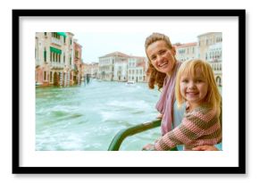 Happy mother and baby girl travel by venice water bus