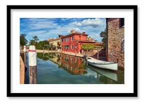 Torcello, Venice. Colorful houses on Torcello island, canal and boats. Summer, Italy
