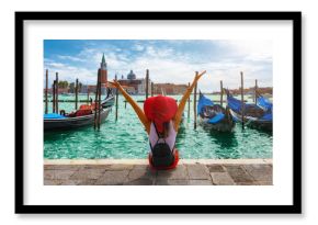 Glückliche Touristin mit rotem Hut genießt die Aussicht auf die Gondeln vom Markusplatz in Venedig, Italien 