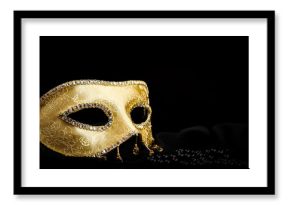 Golden mask near pearls on black