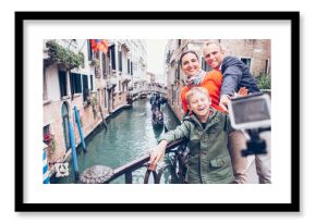 Happy family take a self photo on the bridge over Venecian chann