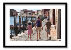 family with mom and two children walking on the island of Murano