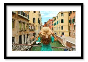 Sweet romantic girl charmed by Venice landscape. Rear view of female tourist on a bridge in Venice, Italy.