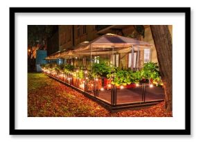 Podświetlony ogródek kawiarniany na krakowskich plantach wśród jesiennych liści