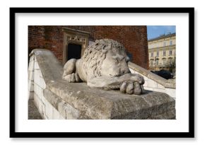 Stone statue of a sleeping lion in front of the Town Hall Tower Kraków on the Main Market Square in Krakow, Poland.