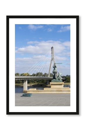 Warsaw mermaid (Syrenka) statue with Holy cross Bridge (Swietokrzyski) in background. Symbol/emblem of Warsaw. Statue made of gunmetal, was erected in April 1939.