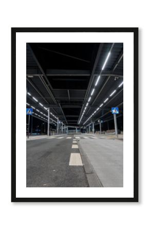 Pusta ulica nocą, znak drogowy z białą strzałką, perspektywa głębi  