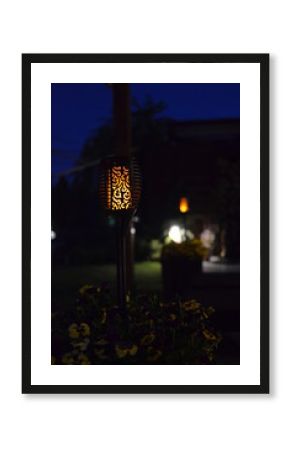 Lampa solarna imitacja płomienia  nocą.