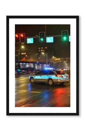 Radiowóz policyjny na sygnale nocą. 