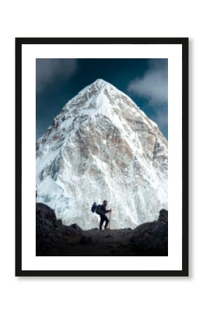 A mountaineer with a backpack observes the great mountain of Pumori while making the ascent to Everest Base Camp in the Himalayas Nepal