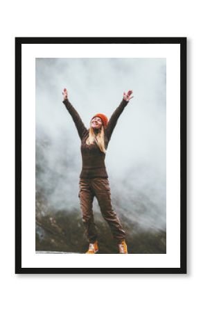 Happy woman in foggy mountains Travel Lifestyle success motivation concept adventure active vacations outdoor blessing emotions raised hands