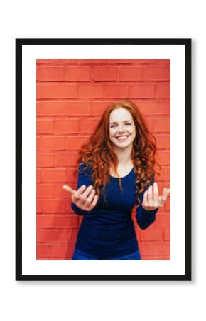 Excited smiling woman standing in front of wall