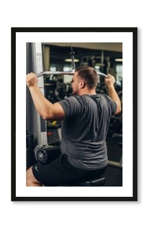Obese man training back at the gym