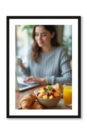 Woman enjoying a healthy breakfast while working on her laptop