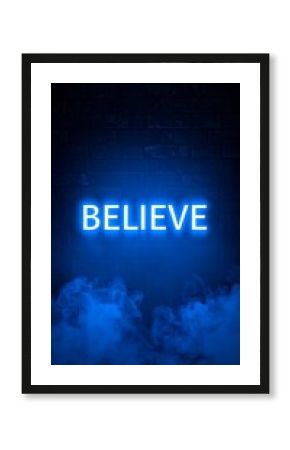 Glowing blue neon word 'Believe' against a dark brick wall backdrop, with blue smoke at the bottom