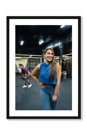 Cheerful hispanic fitness woman smiling while enjoying an energizing workout in a modern gym, embodying a healthy and active lifestyle