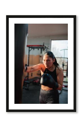 Female Boxer Punching Heavy Bag with Focus