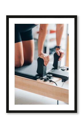 Person Practicing Pilates on a Reformer Machine 