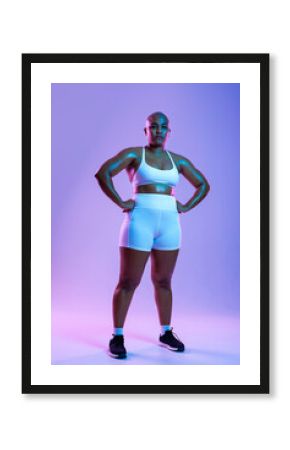 Bald woman in sportswear posing confidently in a studio