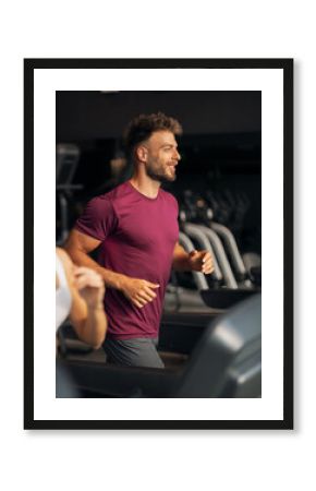 Young Man Running on a Treadmill in Modern Gym